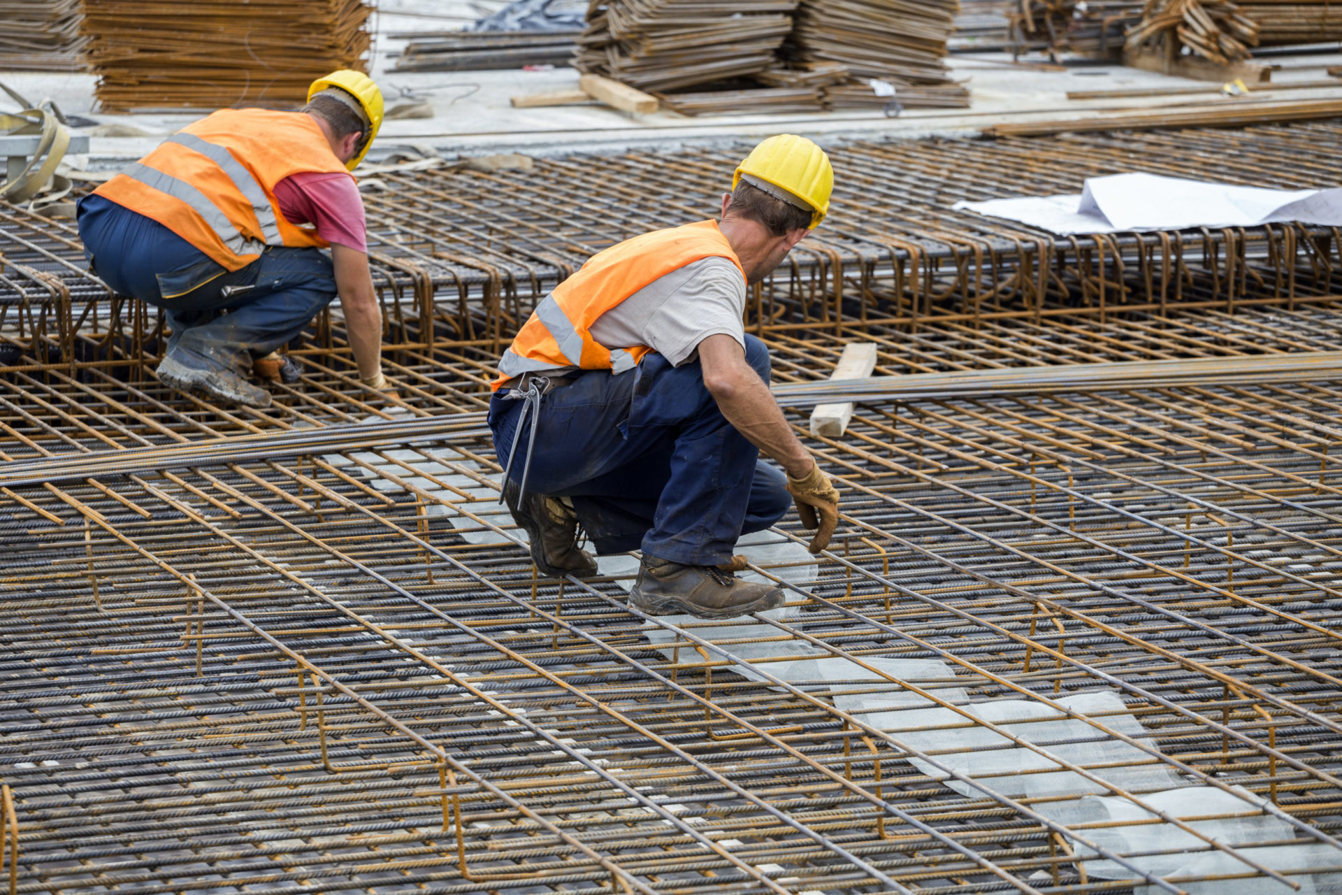 Ironworker workers working on concrete reinforcements at construction site. Reinforcing ironworkers.